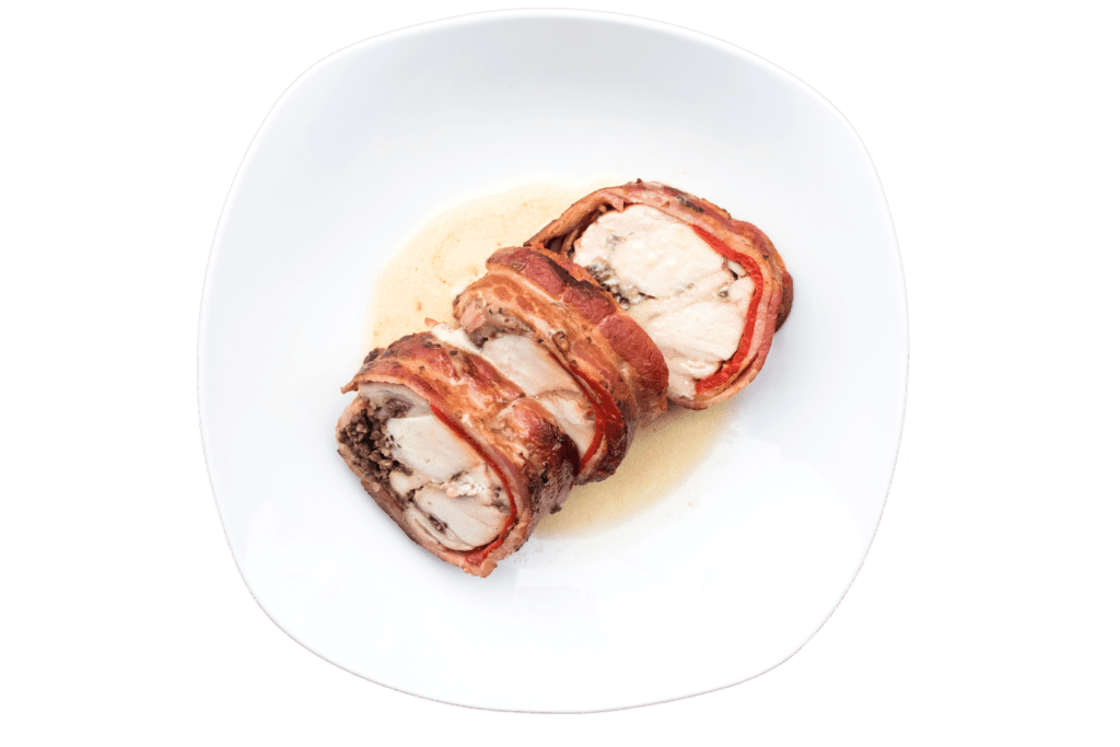 Three slices of prosciutto-wrapped Hermi rabbit saddle roulade with sauce on a white plate.