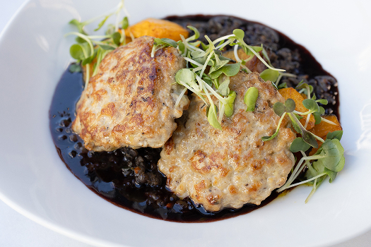 A shallow white bowl holds patties of sauteed ground rabbit and pieces of roasted orange kabocha squash atop black lentils, with a scattering of micros greens on top.  USDA oxtail cut into serving portions with trimmed waste circled in red. Below: Cooked oxtail portions (left) and a whole raw oxtail right.